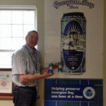 Mayor Braid standing in front of large poster for georgian bay beer